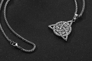 Macro detail of vintage titanium pendant with mystic symbols and braided chain