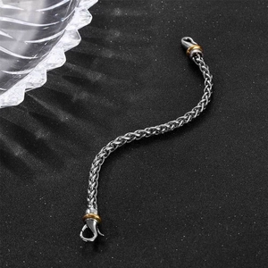 Men hip hop titanium steel braided chain bracelet with gold accents on dark background