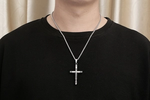 Macro detail of retro stainless steel cross pendant with textured finish for men