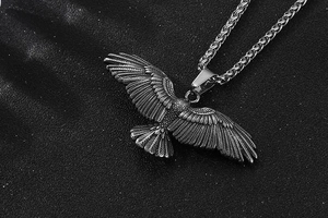 Gros plan détaillé du pendentif aigle avec plumes gravées et finition argent antique