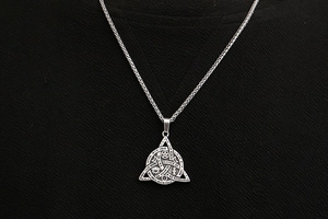 Detailed macro view of silver steel pendant with mystical engravings and engraved phrases