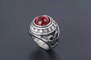 Macro shot of vintage titanium steel ring with red agate and ornate sheep head relief