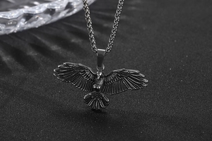 Détail macro du pendentif aigle montrant la texture des plumes et la chaîne punk