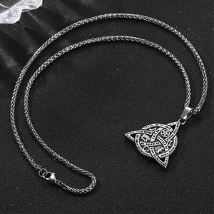 Vintage stainless steel Triquetra pendant necklace with symbolic engravings on black background