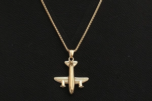 Détail macro d'un collier avion en acier inoxydable plaqué or 18K avec finition poli miroir