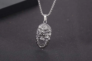 Macro shot of retro Sun Wukong mask pendant in aged titanium steel with fine textures