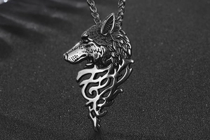 Vue macro d'un pendentif tête de loup avec motifs de flammes en acier inoxydable vieilli