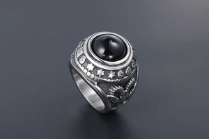 Macro shot of vintage titanium steel ring featuring large black agate and punk carvings