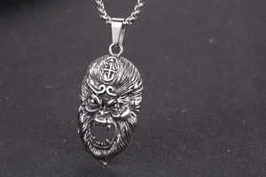 Macro shot of vintage titanium steel Sun Wukong pendant with detailed mask carving