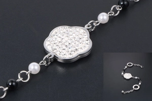 Détail du charm fleur avec zircons et perles sur le bracelet en acier titane argenté