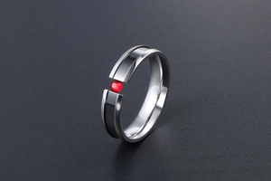 Detail of titanium steel ring with black enamel groove and red zircon inlay