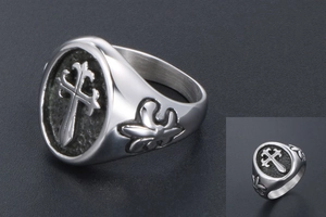 Macro detail of gothic cross relief and vintage floral engraving on steel ring