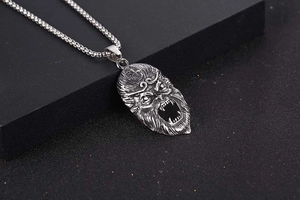 Macro shot of vintage titanium steel Sun Wukong pendant with distressed metallic texture