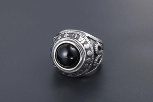 Macro detail of retro men's steel ring with black agate inlay and engraved symbols