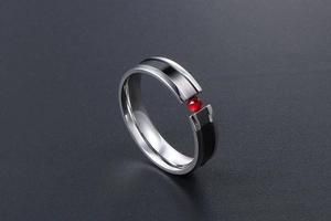 Close-up of silver steel ring with black stripes and a centerpiece red zircon stone