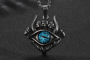 Détail macro du pendentif œil du diable gothique avec crânes et finition en acier