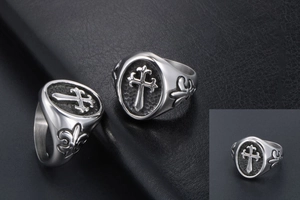 Detail of vintage gothic titanium steel rings with black cross and fleur-de-lis motifs
