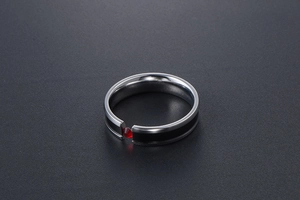 Detailed view of titanium steel ring with black enamel stripe and inset red zircon