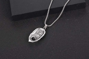Close-up of vintage silver Sun Wukong pendant with natural rock texture on a box