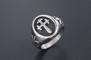 Macro detail of gothic cross signet ring with vintage steel texture and fleur-de-lis relief