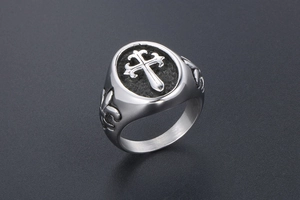 Macro shot of gothic cross ring with fleur-de-lis details on silver stainless steel