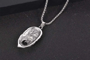 Macro shot of silver titanium pendant featuring rugged rock texture and vintage industrial style