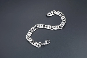 Primo piano del bracciale punk in acciaio argento lucido con maglie a incastro