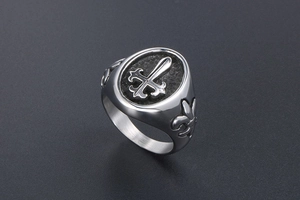 Close-up of vintage titanium steel signet ring with gothic cross and fleur-de-lis detail