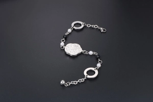 Détail d'un bracelet en titane argenté avec fleurs de perles et fermoir mousqueton