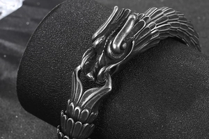 Macro shot of detailed dragon scale texture and vintage carved head on steel bracelet