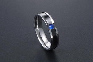 Detail of titanium ring with blue gemstone inlay and black carbon fiber texture
