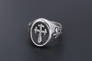 Close-up of gothic cross ring with fleur-de-lis reliefs and polished silver finish