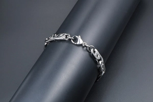 Dettaglio del bracciale punk in acciaio al titanio con maglie geometriche e chiusura a moschettone