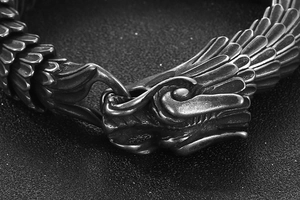 Macro detail of dragon head clasp and dragon scale carvings on vintage steel bracelet