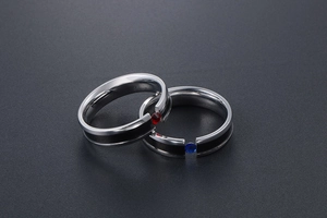 Polished titanium steel couple rings with black inlay and red and blue gemstones