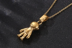 Macro shot of gold-plated astronaut pendant with detailed spacesuit and high-gloss finish