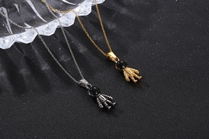 Macro detail of gold and silver astronaut pendants with sleek black visors on dark backgrounds