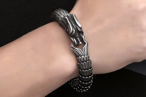 Close-up of vintage silver dragon scale bracelet in stainless steel with detailed carvings