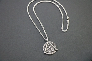 Detail of retro silver Freemason pendant with Eye of Providence and inspirational quotes