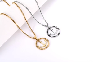 Détail de pendentifs ancre marine en or et argent avec bordure en corde torsadée