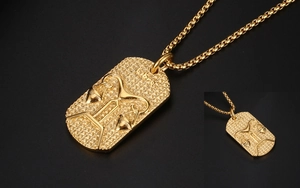 Macro view of Libra zodiac pendant featuring embossed gold scales on a rectangular plate