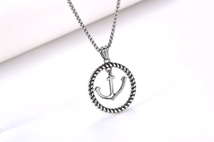 Détail d'un pendentif ancre nautique avec anneau torsadé sur un collier à chaîne box