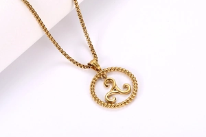 Macro shot of gold triskelion pendant with twisted rope frame and sturdy box chain