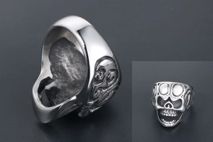 Vue détaillée d'une bague tête de mort argentée avec gravures gothiques et punk