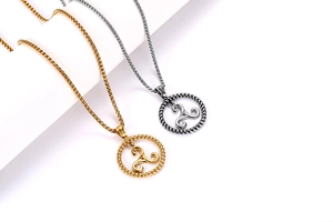 Macro detail of triskelion pendant with twisted rope border on round box chain