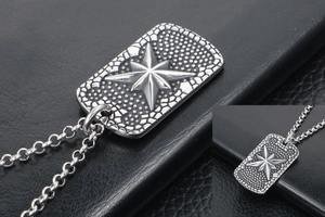 Detailed macro of vintage stainless steel rectangle pendant with embossed star design