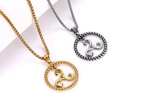 Detailed macro of gold and silver Triskelion pendant necklaces with braided frames
