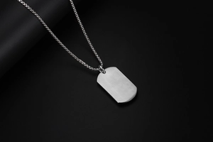 Gros plan sur le collier plaque en acier inoxydable brossé mat avec chaîne à maillons