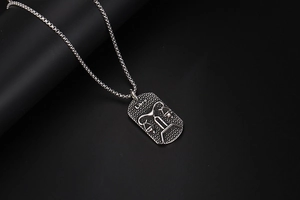 Detail of silver Libra zodiac pendant with hammered texture and vintage metal chain