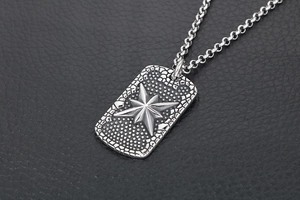 Macro shot of silver rectangular military tag pendant with embossed star on rulo chain